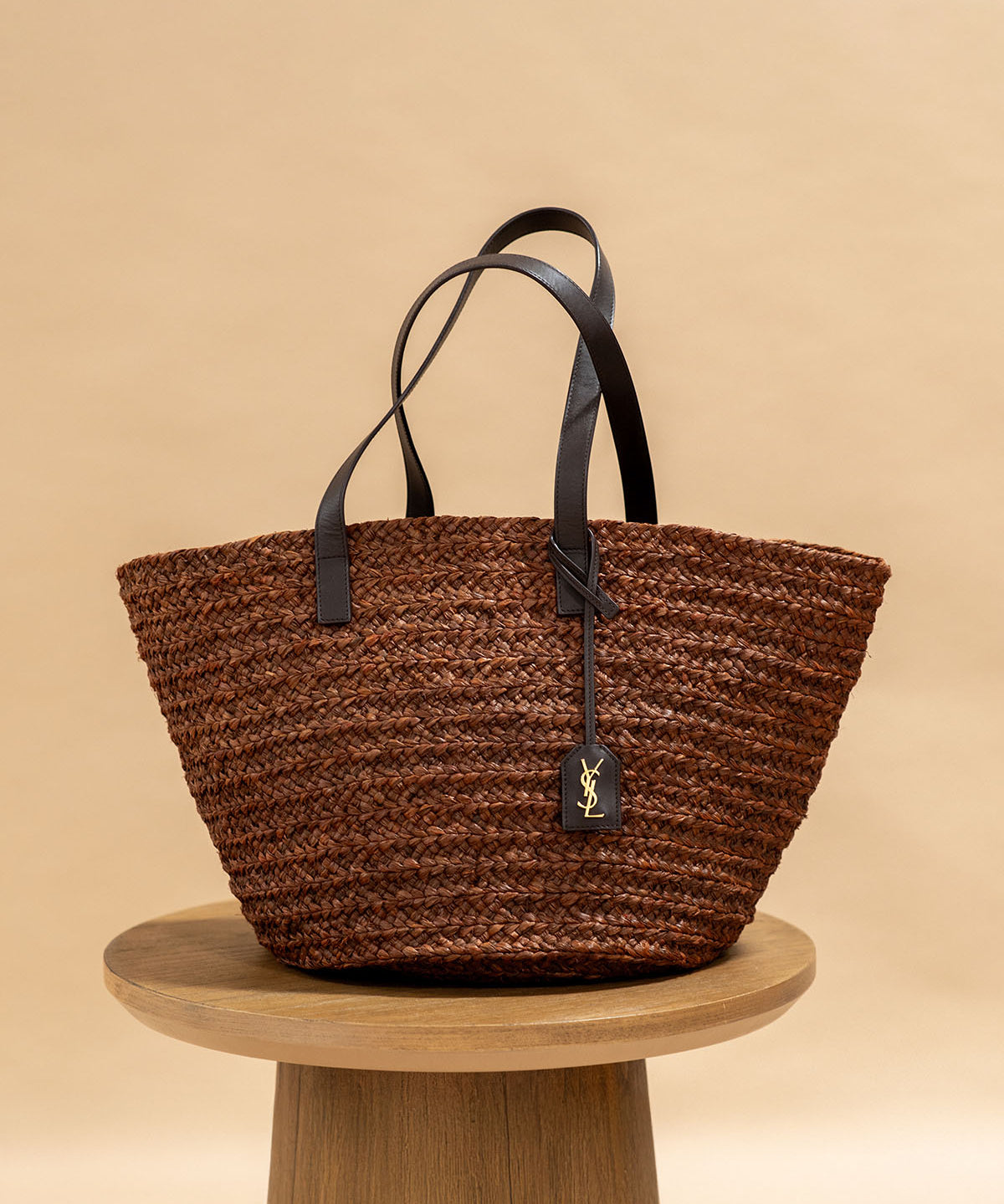 YSL Brown Woven Raffia Panier Tote on a wooden stool