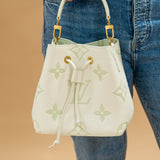 Louis Vuitton Bicolor Monogram Matcha Empriente Neo held in a hand agains jeans